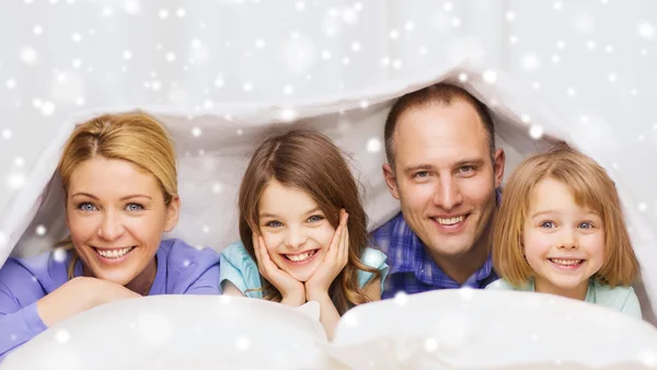 Happy family with two kids under blanket at home Royalty Free Stock Photos