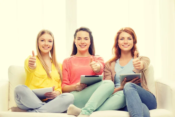 Three smiling teenage girls with tablet pc at home — Stock Photo, Image