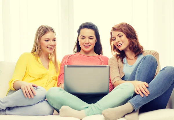 Tres niñas adolescentes sonrientes con ordenador portátil en casa — Foto de Stock