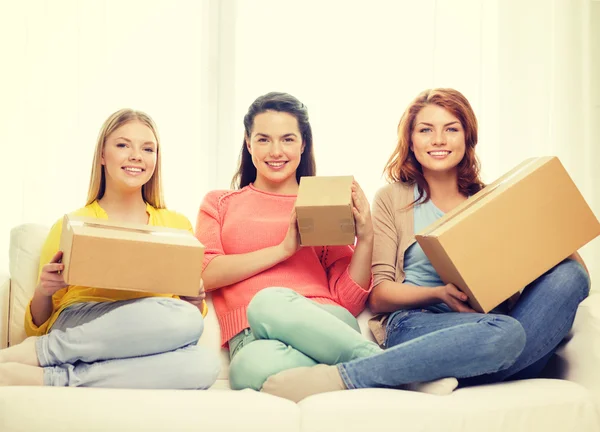 Niñas adolescentes sonrientes con cajas de cartón en casa — Foto de Stock