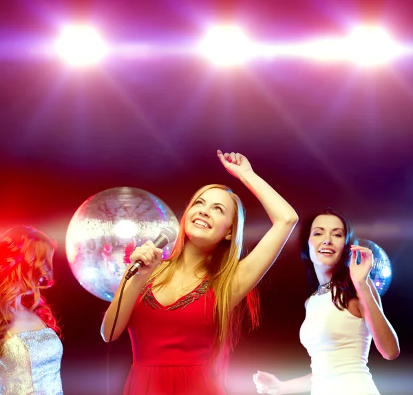 Tre donne sorridenti che ballano e cantano karaoke — Foto Stock