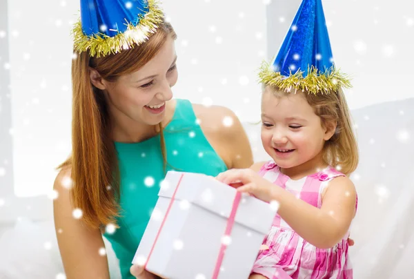 Mãe e filha em chapéus de festa com caixa de presente — Fotografia de Stock