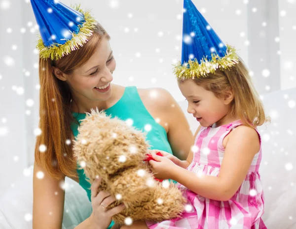 Mãe e filha em chapéus de festa com brinquedo — Fotografia de Stock