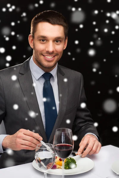 Hombre sonriente con la tableta PC comer plato principal — Foto de Stock