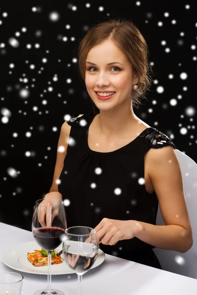 Mujer sonriente con la tableta PC comer plato principal — Foto de Stock