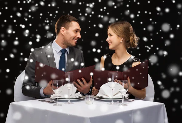 Smiling couple with menus at restaurant — Stock Photo, Image