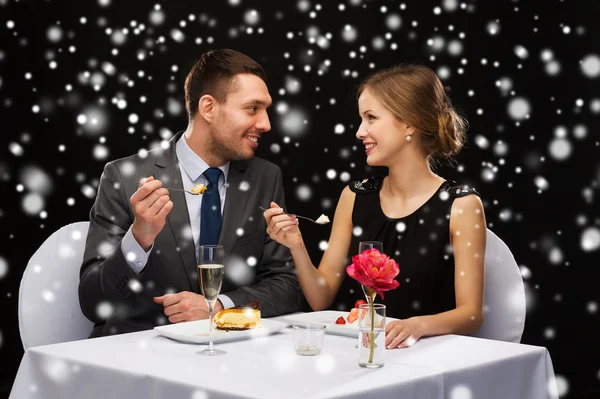 Smiling couple eating dessert at restaurant — Stock Photo, Image