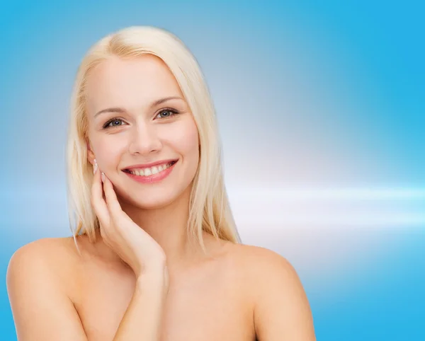 Smiling young woman touching her face skin — Stock Photo, Image