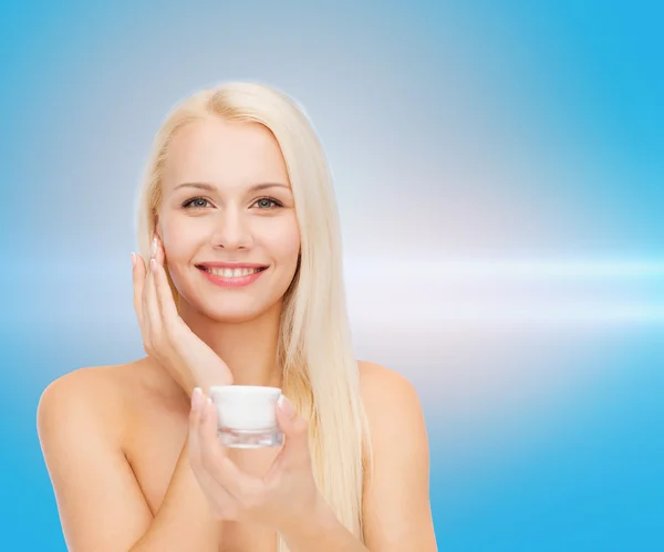 Mujer aplicando crema en su piel — Foto de Stock