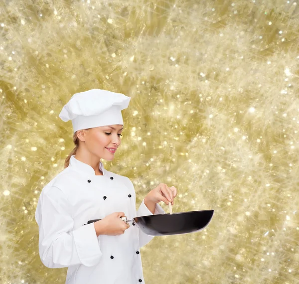 Usmívající se žena šéfkuchař s pan a lžíce — Stock fotografie