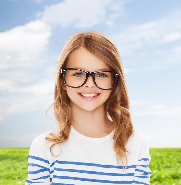 Sorrindo bonito menina com óculos pretos — Fotografia de Stock