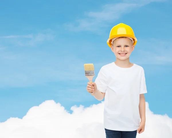 Smiling little boy in helmet with paint brush — Stock Photo, Image