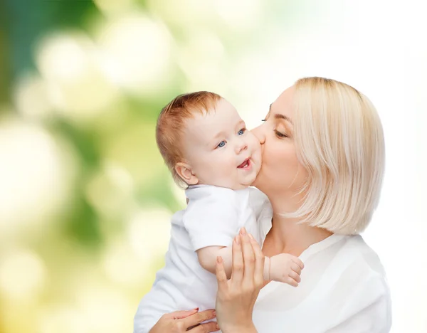 Szczęśliwa matka całuje dziecko uśmiechający się — Zdjęcie stockowe