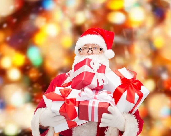 Man in kostuum van de kerstman met geschenkdozen — Stockfoto