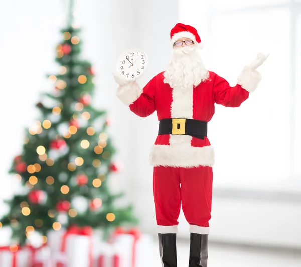 Man in costume of santa claus with clock — Stock Photo, Image