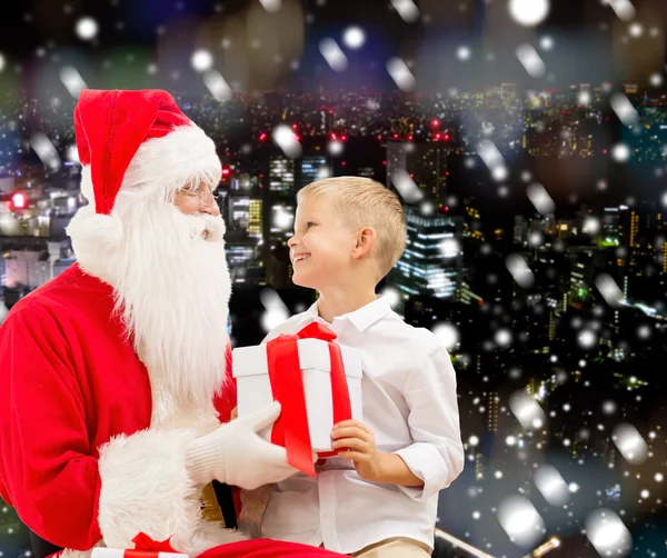 Smiling little boy with santa claus and gifts — Stock Photo, Image