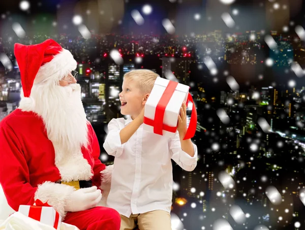 Smiling little boy with santa claus and gifts — Stock Photo, Image