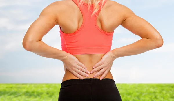 Close up of sporty woman touching her back Royalty Free Stock Images