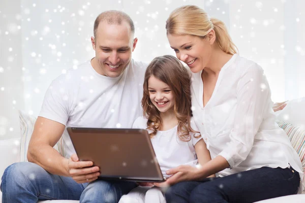 Smiling family with laptop at home — Stock Photo, Image