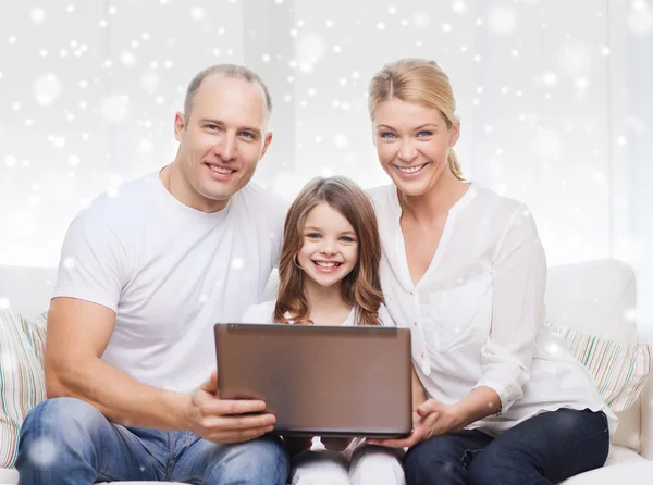 Familia sonriente con portátil en casa —  Fotos de Stock