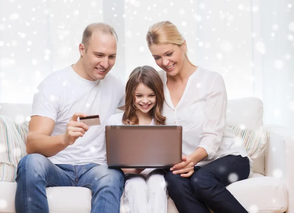 Happy family with laptop computer and credit card — Stock Photo, Image