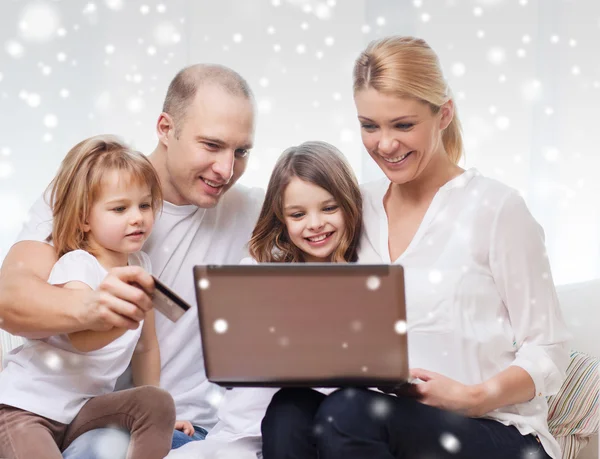 Gelukkige familie met laptopcomputer en credit card — Stockfoto