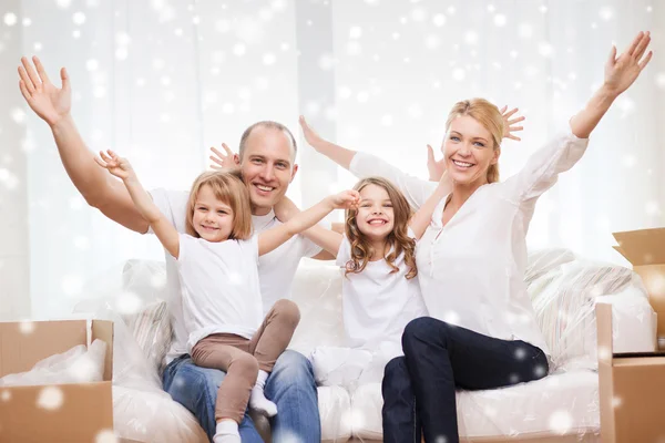 Lächelnde Eltern und zwei kleine Mädchen im neuen Zuhause — Stockfoto