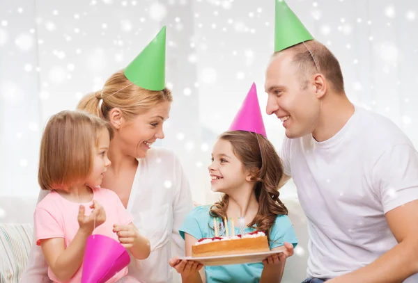 Família feliz com dois filhos em chapéus de festa em casa — Fotografia de Stock