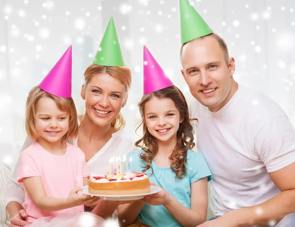 Famille heureuse avec deux enfants dans des chapeaux de fête à la maison — Photo