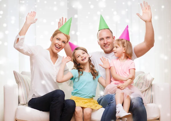 Happy family with two kids in party hats at home — Stock Photo, Image