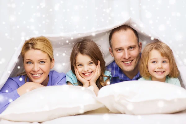Šťastná rodina s dvěma dětmi pod deku doma — Stock fotografie