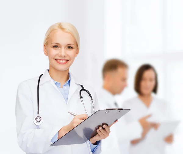 Smiling female doctor with clipboard — Stock Photo, Image