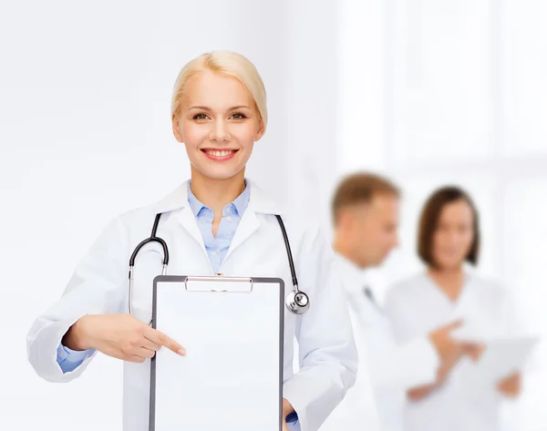 Usmívající se žena doktor s schránky — Stock fotografie