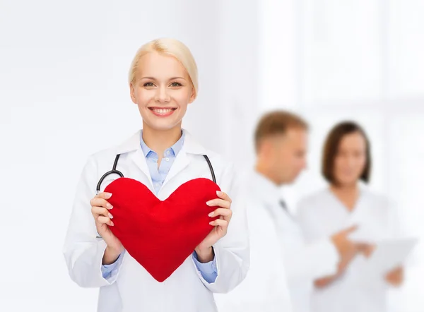 Doctora sonriente con corazón y estetoscopio — Foto de Stock