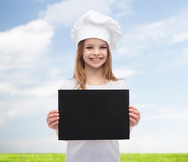 Little cook or baker with blank black paper — Stock Photo, Image