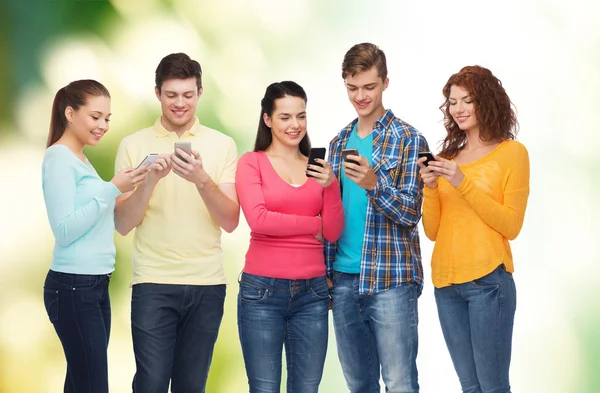 Grupo de adolescentes sonrientes con teléfonos inteligentes — Foto de Stock