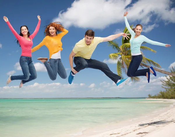 Groep van lachende tieners springen in de lucht — Stockfoto