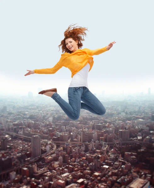 Souriant jeune femme sautant haut dans l'air — Photo