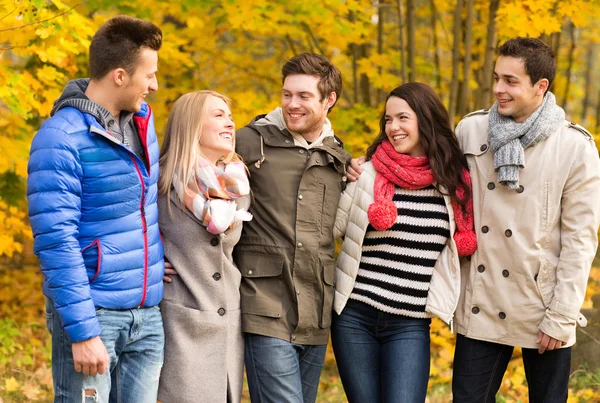 Grupo de hombres y mujeres sonrientes en el parque de otoño —  Fotos de Stock