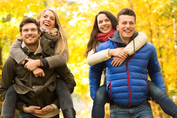 Glimlachende vrienden vermaken in herfst park — Stockfoto