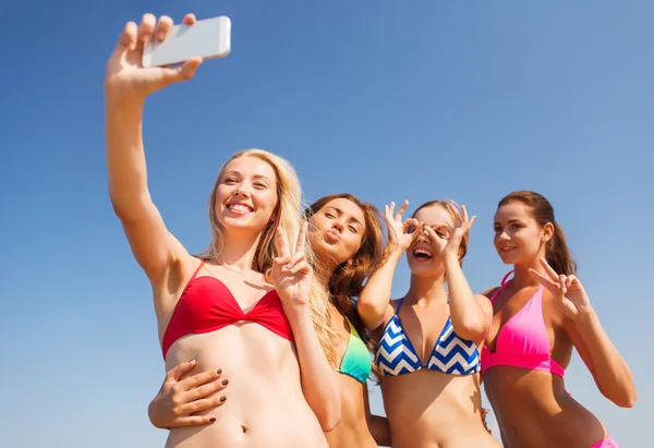 Grupa kobiet uśmiechający się co selfie na plaży — Zdjęcie stockowe