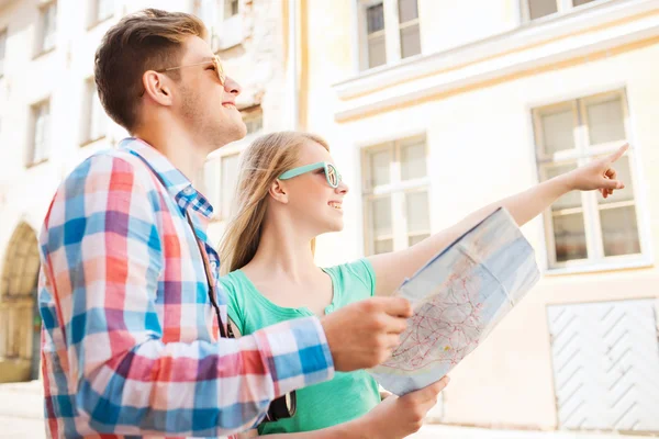 Smiling couple with map and photo camera in city — Stock Photo, Image