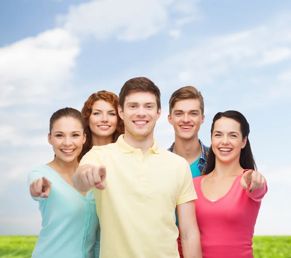 Groep van lachende tieners over blauwe hemel en gras — Stockfoto