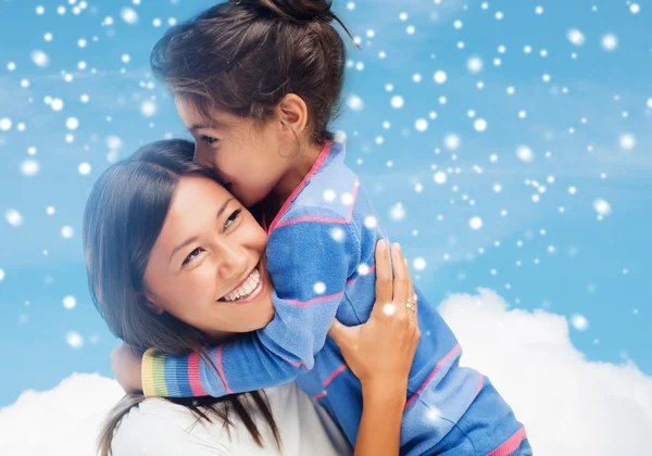 Sorridente bambina e madre che si abbraccia in casa — Foto Stock