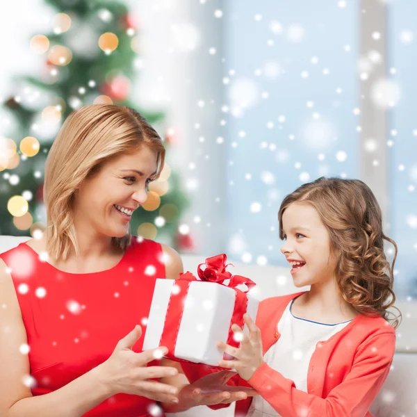 Smiling mother and daughter with gift box at home — Stock Photo, Image