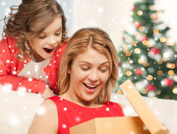 Sonrientes madre e hija con caja de regalo en casa — Foto de Stock