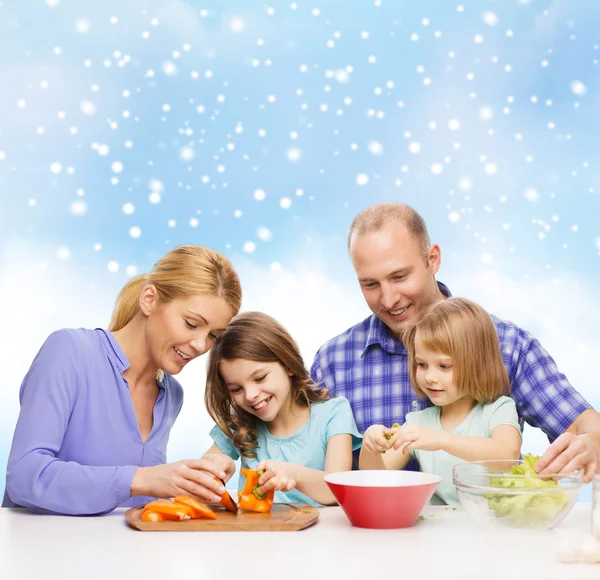 Счастливая семья с двумя детьми готовит ужин дома — стоковое фото