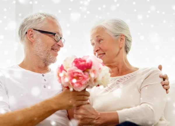 Felice coppia anziana con mazzo di fiori a casa — Foto Stock