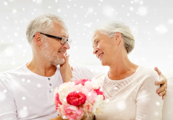 Feliz pareja de ancianos con ramo de flores en casa — Foto de Stock