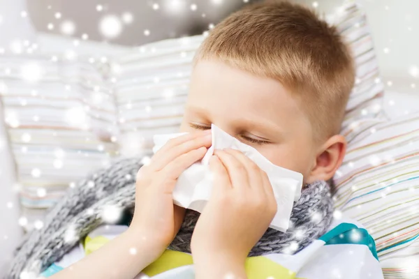 Niño enfermo que sopla la nariz con tejido en casa — Foto de Stock